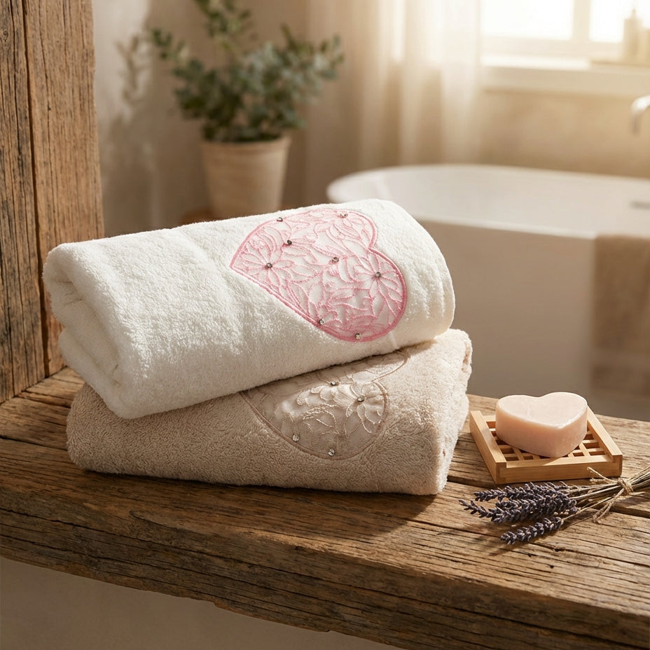 Two towels stacked on a wooden shelf with a plant and soap in the background